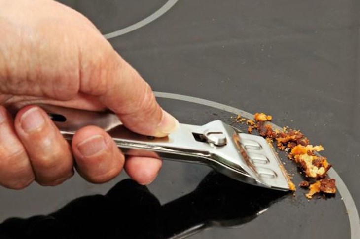 Cạo sạch các vết cháy khét và mảng thức ăn bám lâu ngày trên bề mặt bếp