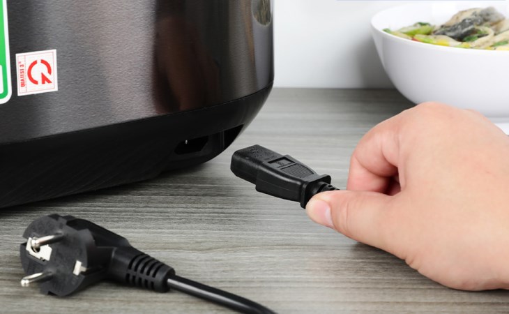 Bạn cắm dây nguồn của nồi cơm điện tử Sharp 1.8 lít KS-COM194EV-BK vào ổ điện để tiến hành nấu cơm