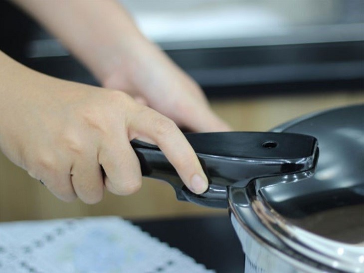 Dùng tay vặn của nồi và vặn ngược chiều nhau để tách nồi và nắp Dùng tay vặn của nồi và vặn ngược chiều nhau để tách nồi và nắp