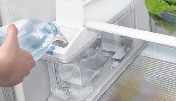 Đổ nước vào bình chứa nước của tủ lạnh để làm đá